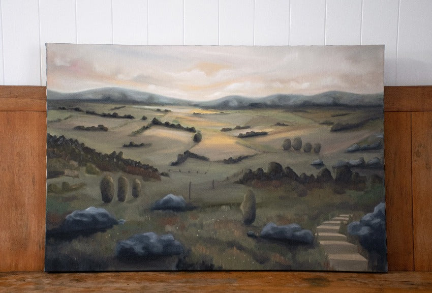 Large oil painting of sunset over rural landscape